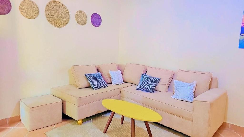 a living room with a couch with pillows and a table at Kilifi Beach Haven -Cozy 1 bedroom apartment in Kilifi