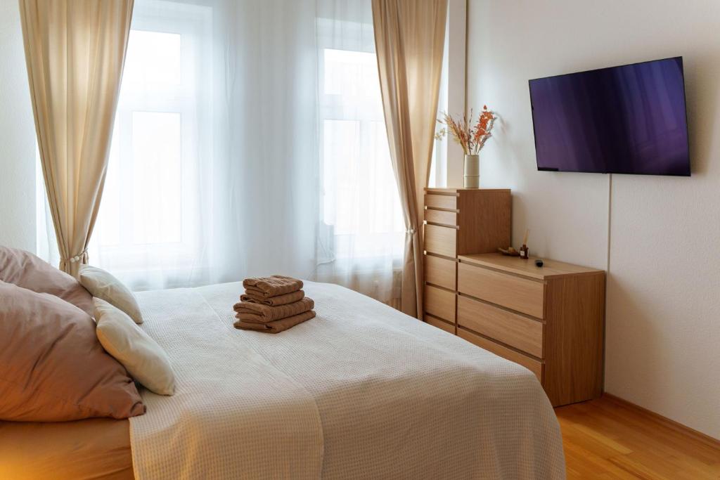 a bedroom with a bed with a tv on the wall at Gemütliche 2-Raum-Wohnung in Leipzig
