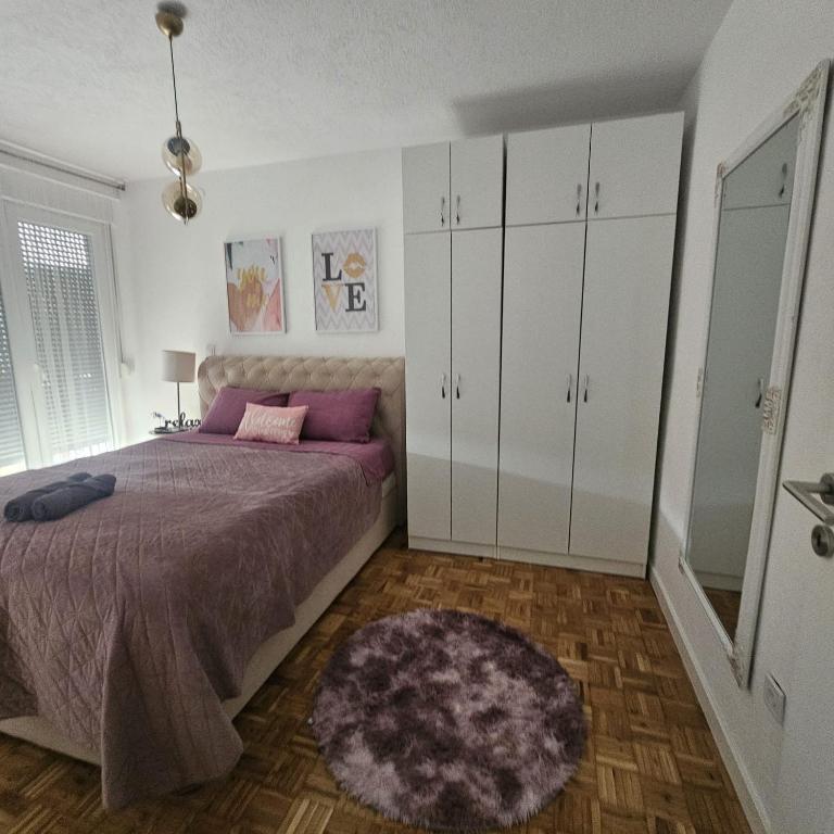 a bedroom with a bed and white cabinets and a rug at FRIENDLY HOME in Tuzla