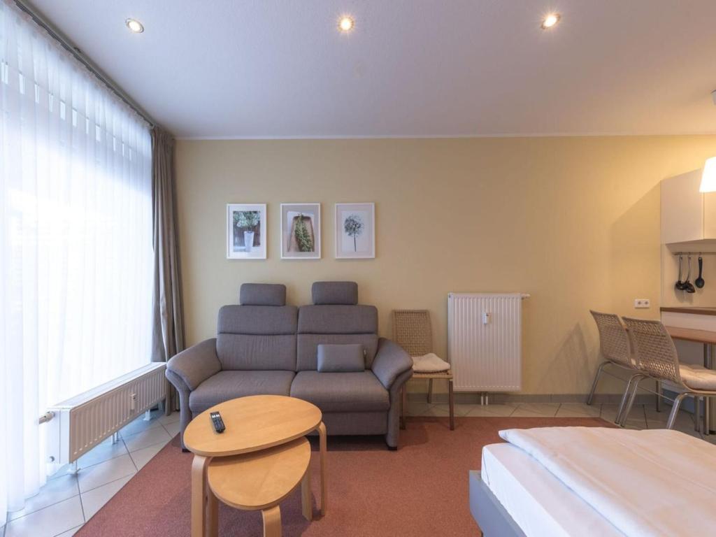 a living room with a couch and a table at Ferienwohnung im Aparthotel Seepanorama in Granzow