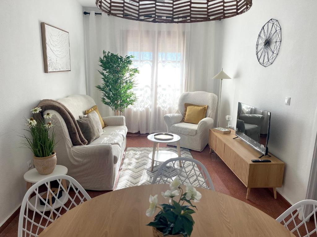 un soggiorno con un divano, sedie e un tavolo di Apartamento Laurencia a Fuente Obejuna