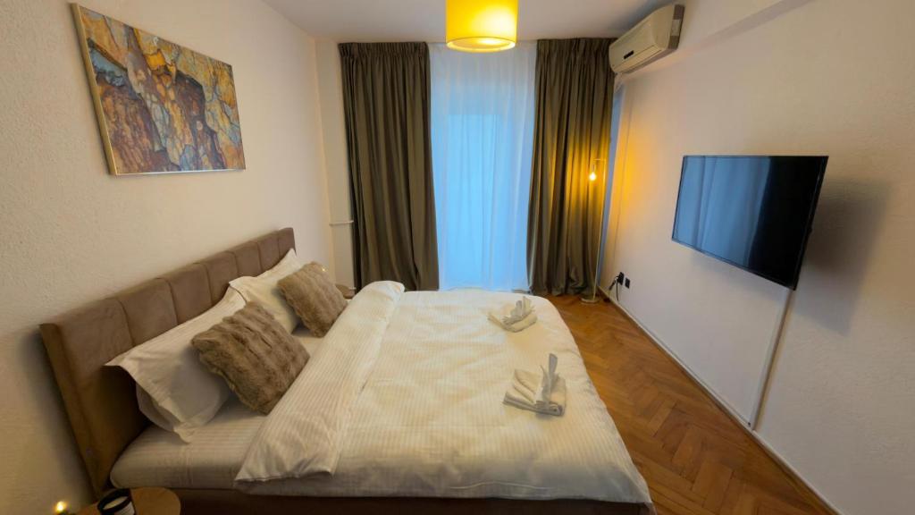 a bedroom with a bed and a flat screen tv at Ultracentral 13 in Craiova