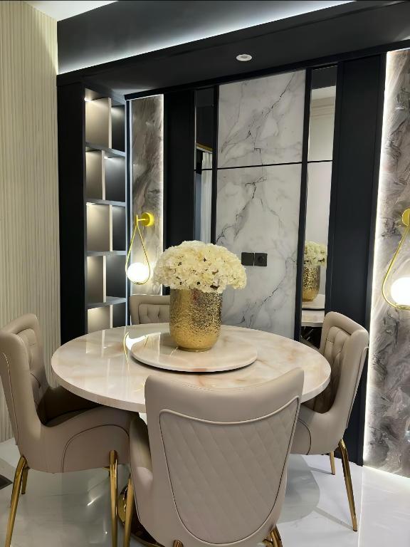 a dining room with a table with a vase of flowers at Delft Apartemen in Gusung