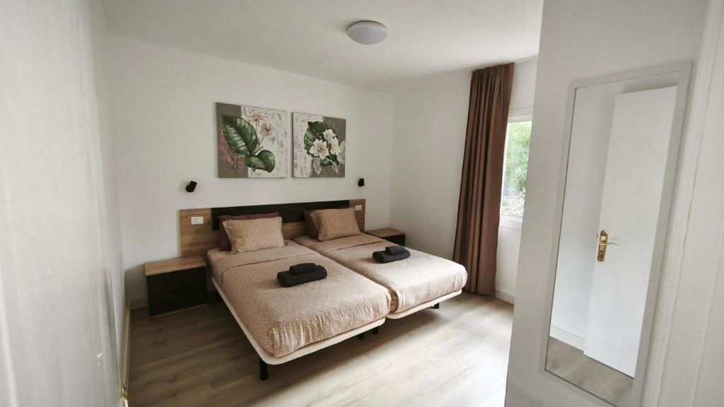 ein Schlafzimmer mit einem Bett mit zwei Hüten darauf in der Unterkunft Take it easy in Corralejo in Corralejo