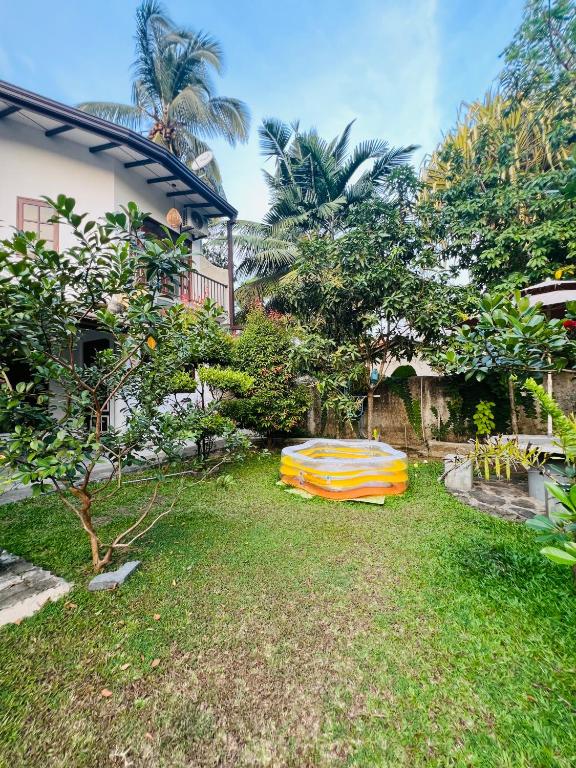 a yard with a surfboard sitting in the grass at Villa N in Unawatuna