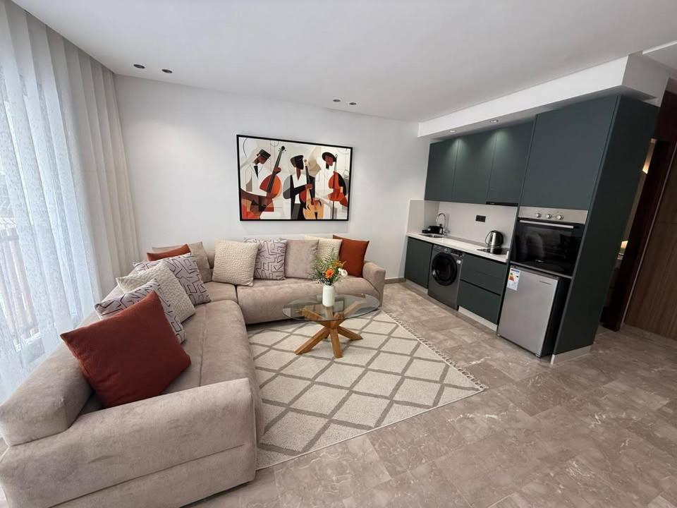 a living room with a couch and a kitchen at bel et comfortable appartement centre agdal in Rabat