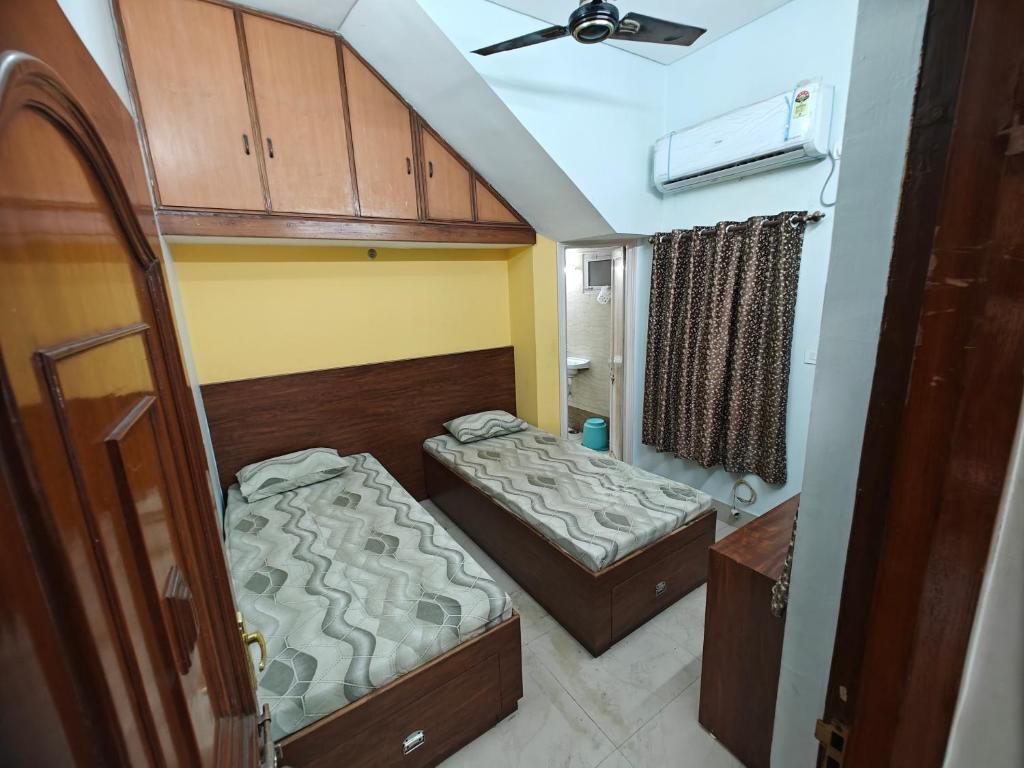 Una pequeña habitación con dos camas y un techo. en Comic hotel, en Raipur