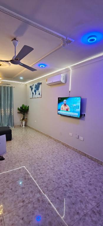 a living room with a flat screen tv on a wall at Purple Springs Elmina Suite #3 in Esamang