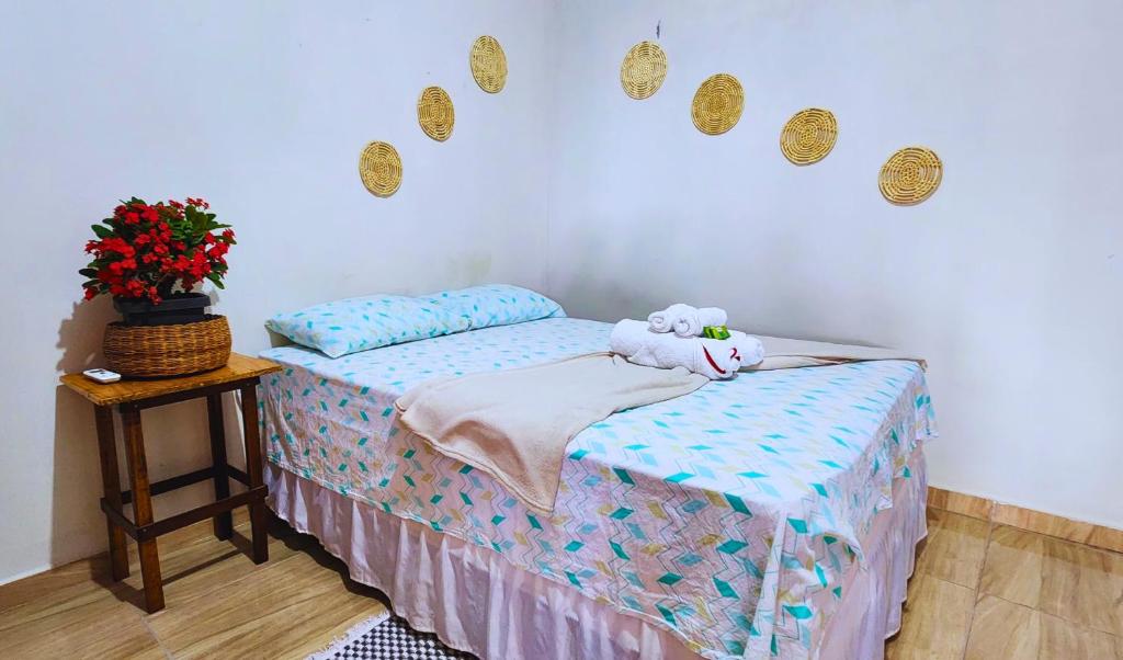 a bedroom with a bed with a stuffed animal on it at Hospedaria Oliveira - Santo Amaro do Maranhão in Queimada