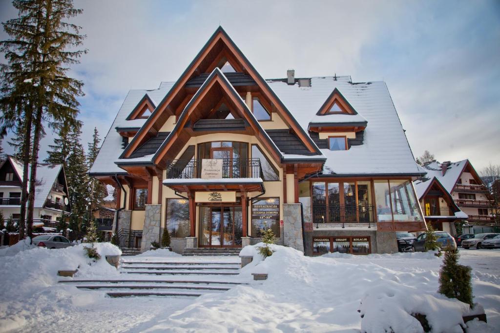 Chalet-style hotel facade with steep gabled roofs and snow-covered entrance steps