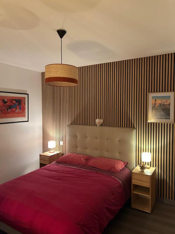 1 dormitorio con 1 cama grande de color rojo y 2 lámparas en Chez Olivier et Damien, en La Roche-sur-Yon