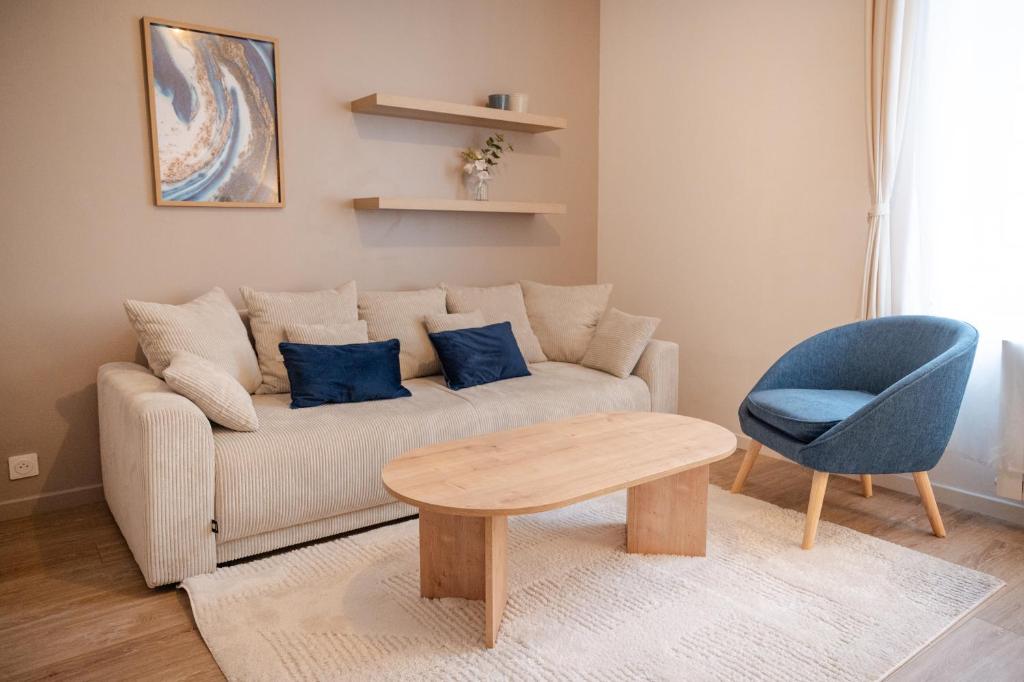 a living room with a couch and a table and a chair at Saint-Fons centre appartement meublé in Saint-Fons