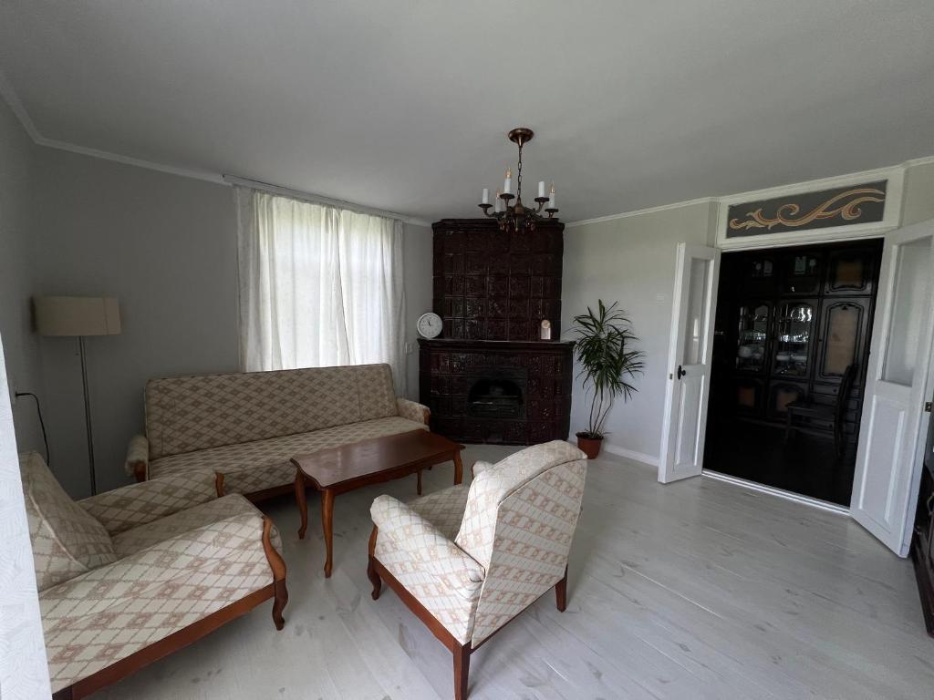 een woonkamer met een bank en stoelen en een open haard bij Яблунева садиба 