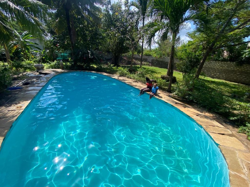 un bambino è seduto in una piscina di Villa Soleil a Diani Beach