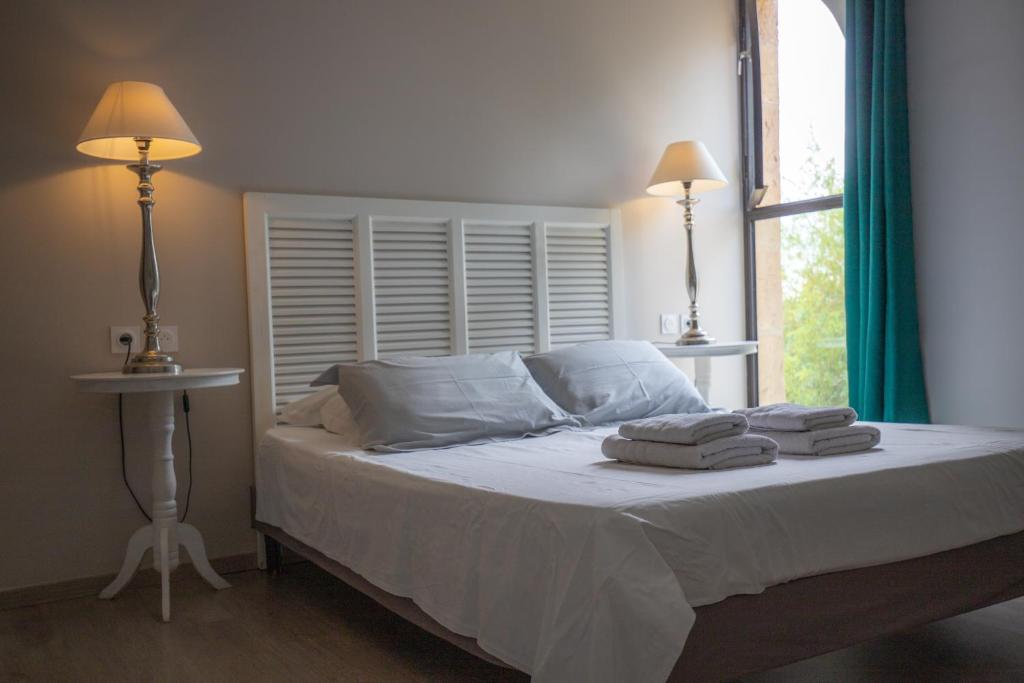 a bedroom with a bed with two towels on it at B&B Maison d'hôte et gite Mas d'Eymard in Arles