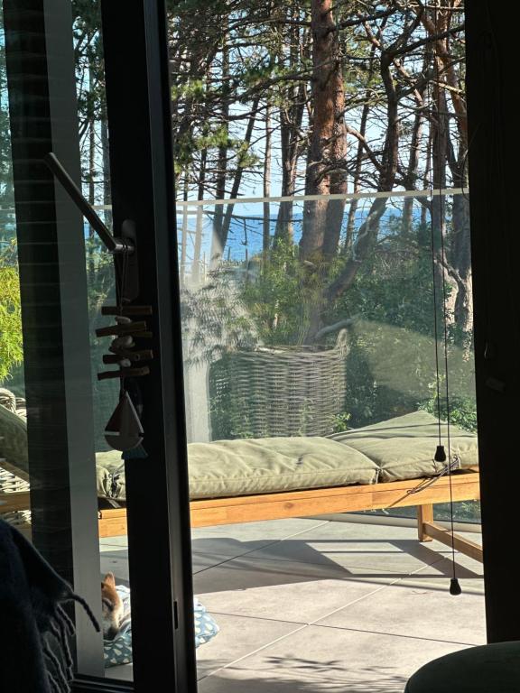 a sliding glass door with a couch on a porch at likehevenpogorzelica in Pogorzelica