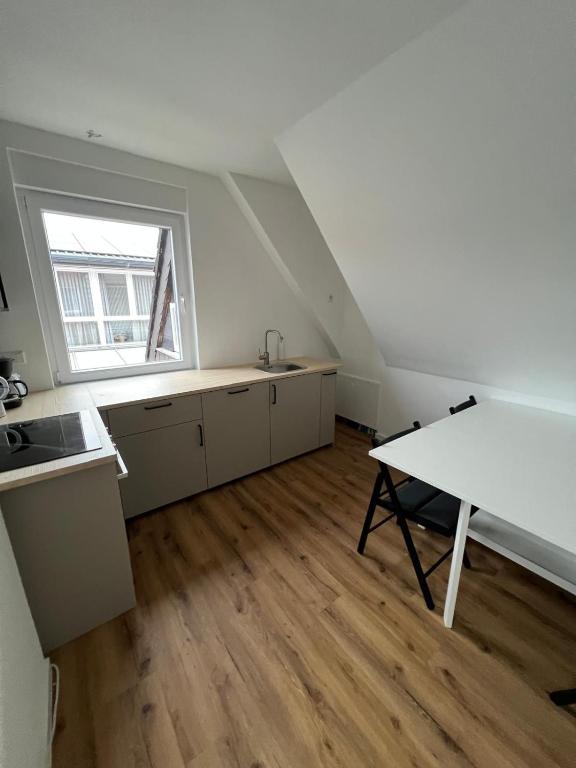 an attic kitchen with a table and a window at Monteurswohnung Mesum in Rheine
