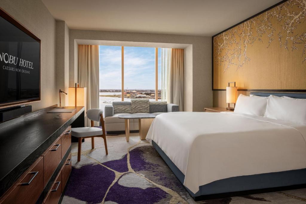 a hotel room with a large bed and a television at Nobu Hotel New Orleans - A Caesars Rewards Destination in New Orleans