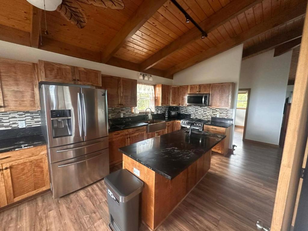 a kitchen with a stainless steel refrigerator and wooden cabinets at The Gray House 