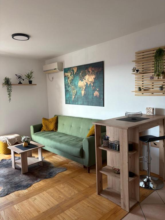 a living room with a green couch and a table at Apartman *Joy* in Osijek