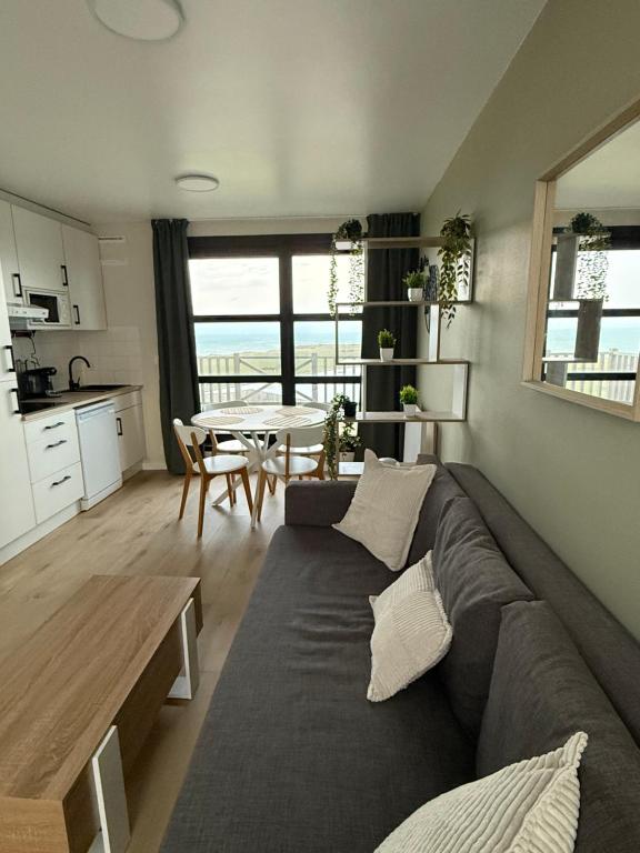 ein Wohnzimmer mit Sofa und Tisch in der Unterkunft La Naturelle 123 - Duplex Vue Mer Wimereux in Wimereux