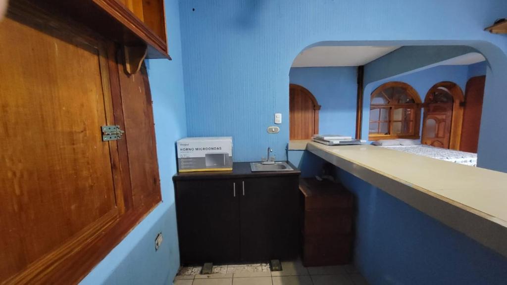 a kitchen with blue walls and a counter with a sink at Casa Maya Vibes in Santiago Atitlán