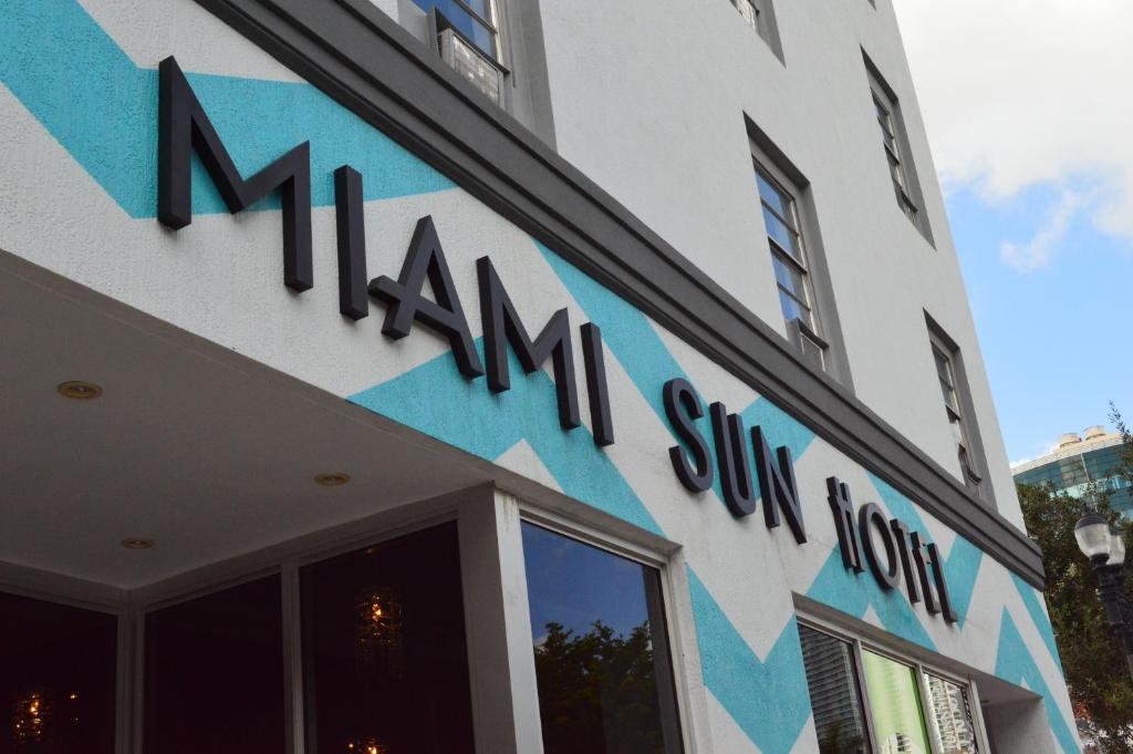 a building with a sign on the front of a store at Miami Sun Hotel - Downtown/Port of Miami in Miami