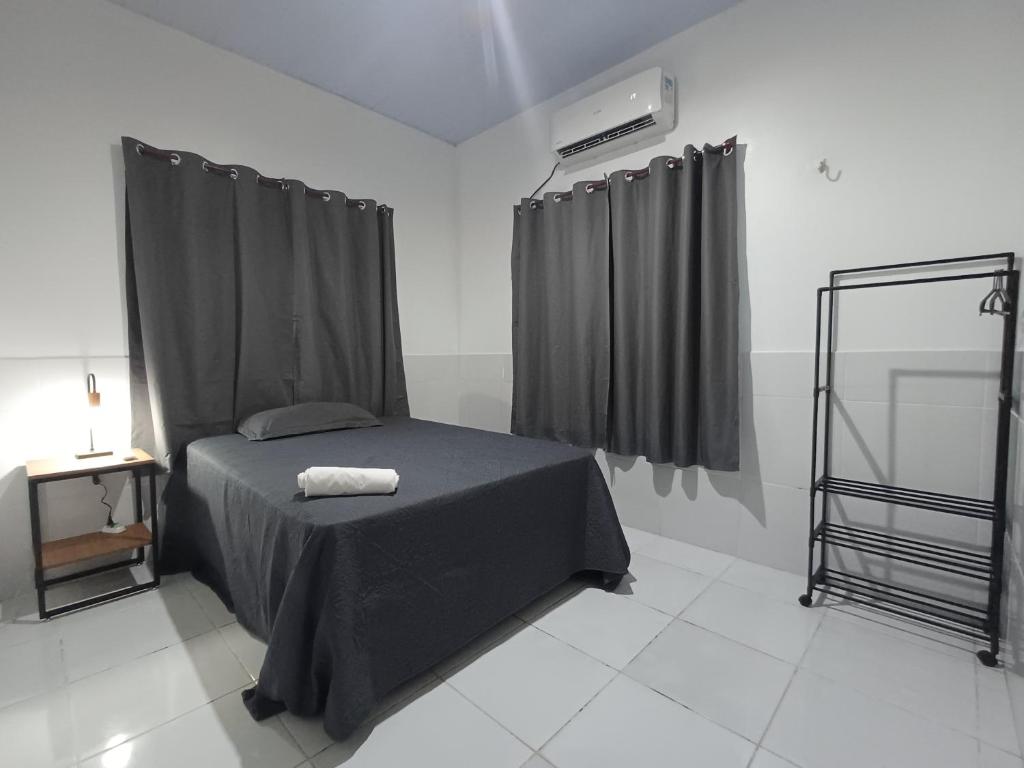 JurutiにあるResidêncial Fonsecaのベッドルーム1室(黒いシーツとカーテンのベッド1台付)
