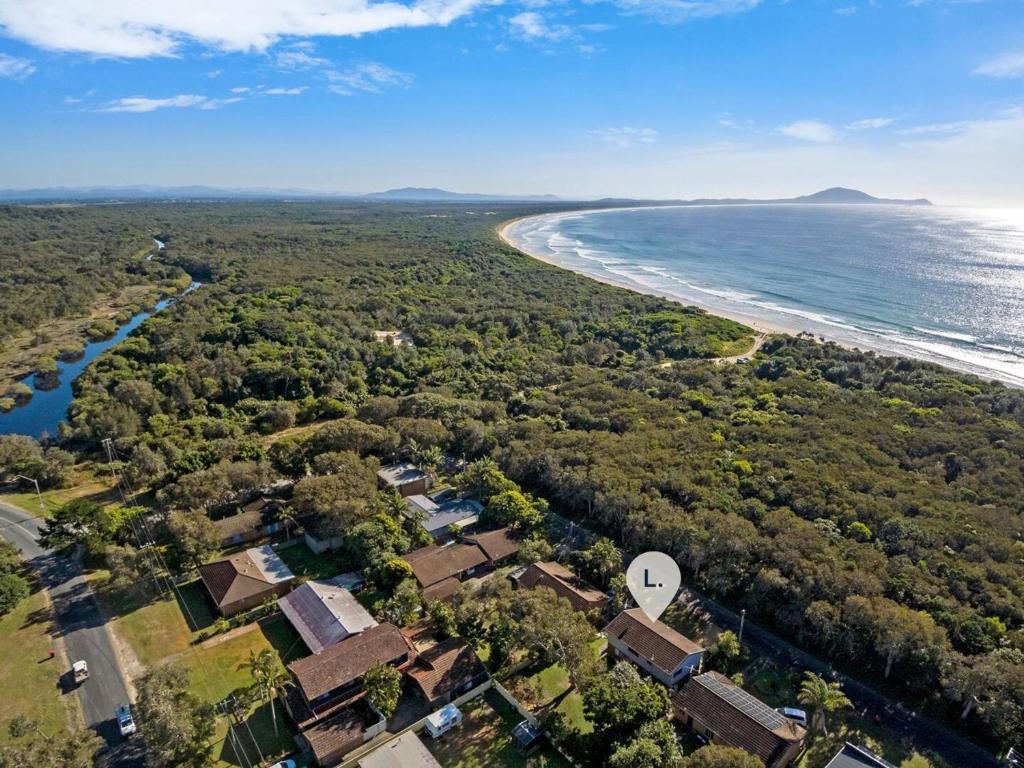 an aerial view of a beach with houses and the ocean at Ammaboolah at Hat Head - 36 Hutcheson Street in Hat Head