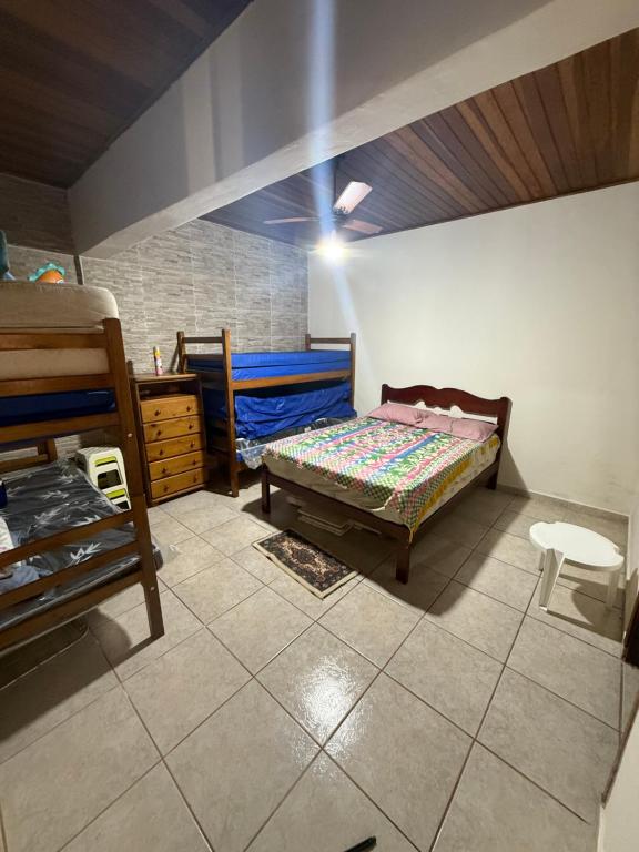 een slaapkamer met een bed en een ladekast erin bij Casa com Espaço Gourmet e Piscina a 2min da Praia in Caraguatatuba