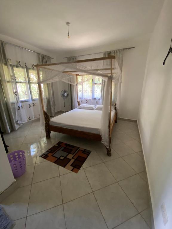 Double Room at Villa Soleil في شاطئ دياني: غرفة نوم بها سرير أبيض في الغرفة