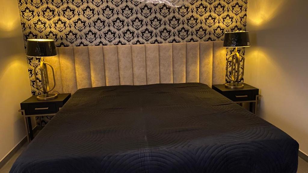 a bedroom with a bed with two lamps on it at SuiteDreams - Ruby Suite Liège in Liège