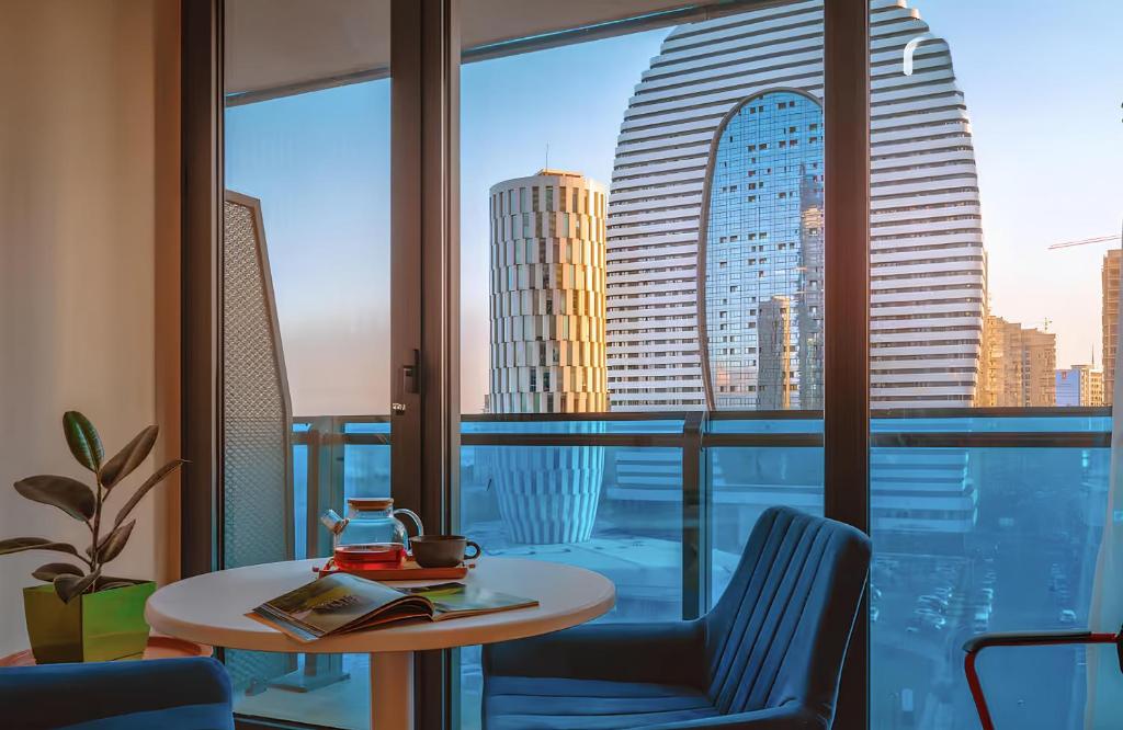 Una mesa y sillas en una habitación con vistas a una ciudad. en Panorama Luxurious with sea view Hotel, en Batumi