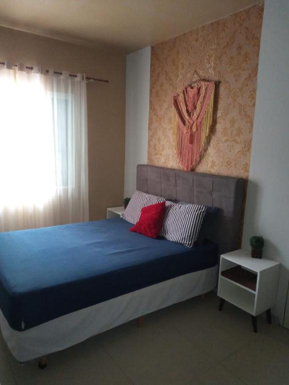 a bedroom with a blue bed with red pillows at casas praias familiar in Piçarras