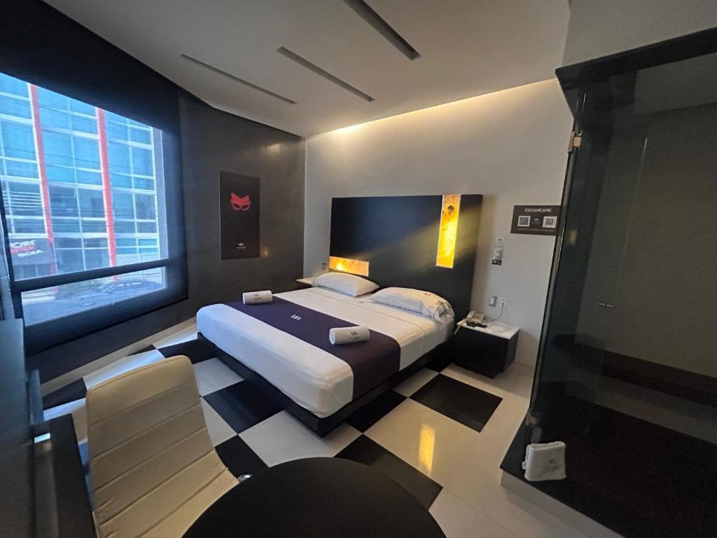 a bedroom with a bed and a large window at Auto Hotel Via Uno in Boca del Río