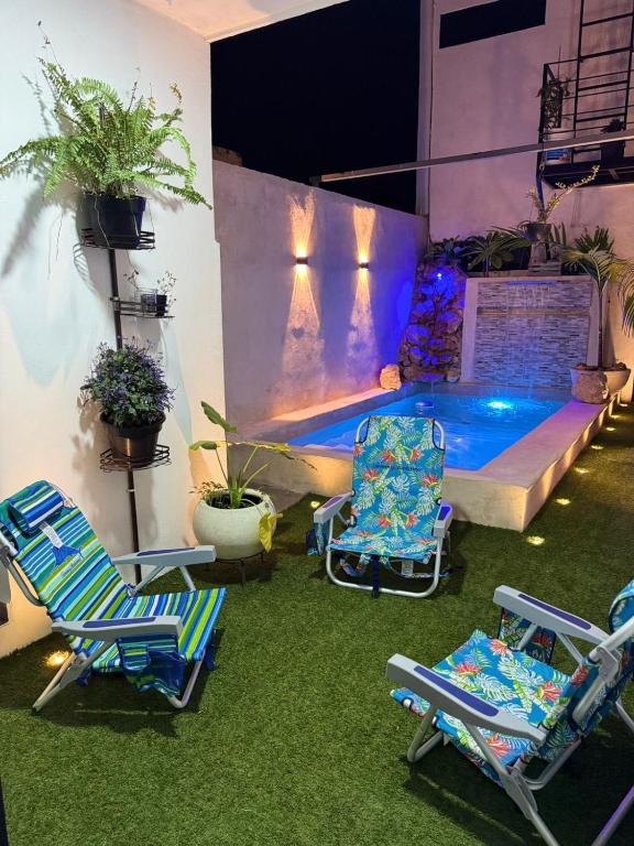a patio with two chairs and a swimming pool at Loft's PB in Mérida
