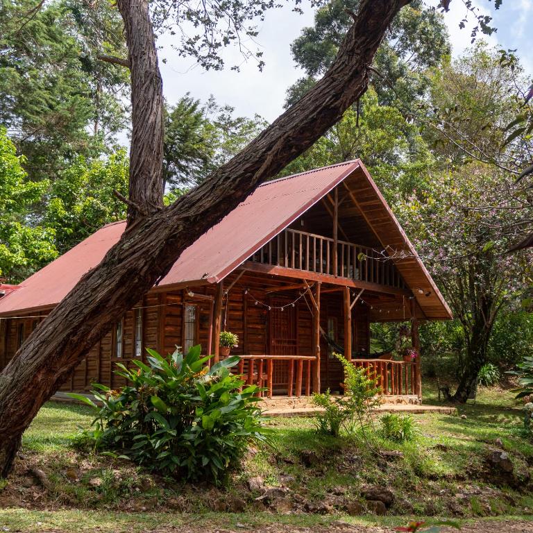 a log cabin with a red roof at Cabañas El Coyote in San Pablo