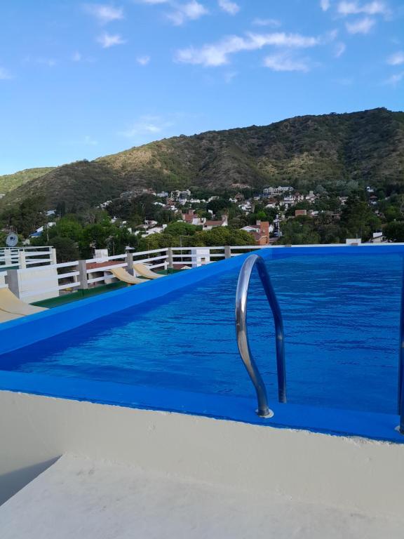 a infinity pool with a metalaucet on the edge at Departamento Anita Villa Carlos Paz in Villa Carlos Paz