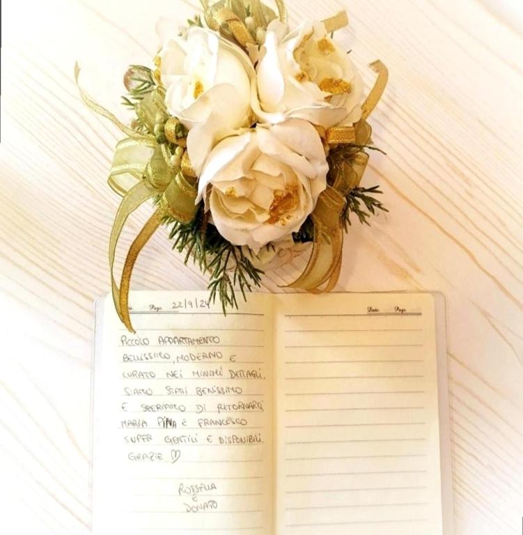 a book with a bouquet of flowers on top of it at Calin Apartment in Turin