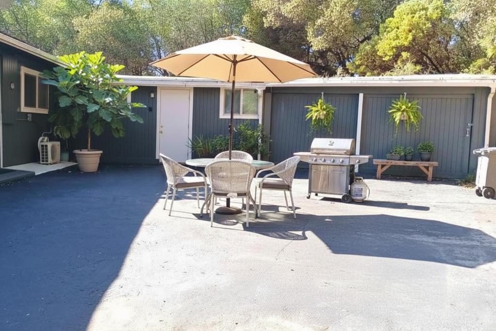eine Terrasse mit Tisch, Stühlen und Sonnenschirm in der Unterkunft Budget-Friendly Auburn Retreat in Auburn