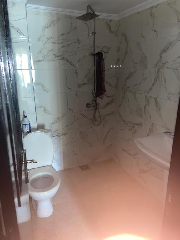 a bathroom with a white toilet and a sink at Résidence TPM in Casablanca