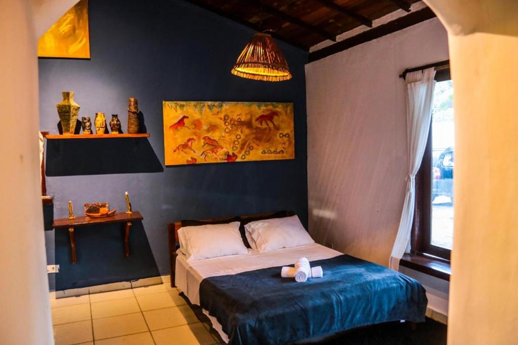 Ateliê Cultural Trancoso في ترانكوسو: غرفة نوم بسرير وجدار ازرق