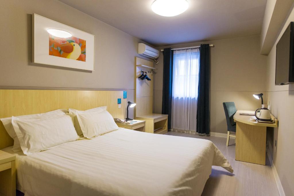 a hotel room with a white bed and a window at Jinjiang Inn Yulin High Tech. Zone Donghuan Road in Yulin