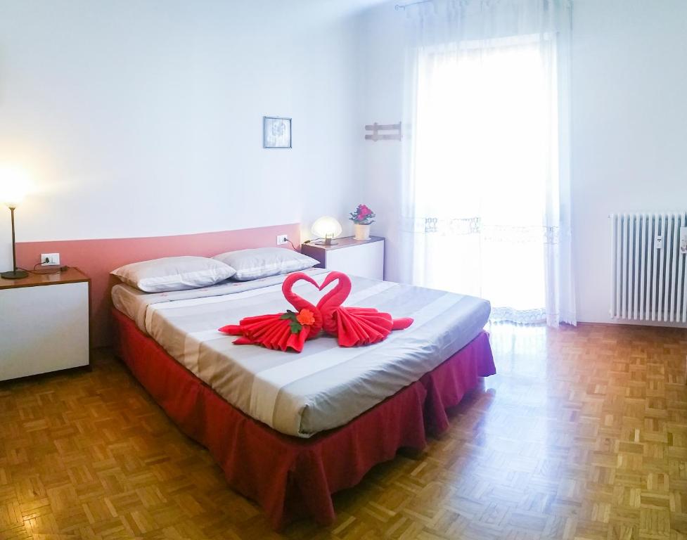 Rosso Tirano في تيرانو: غرفة نوم مع سرير عليها قوس احمر