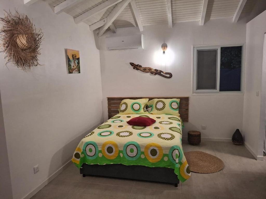 Maison cosy à Sainte-Anne - 31 m² avec terrasse في Douville: غرفة نوم مع سرير مع لحاف أخضر