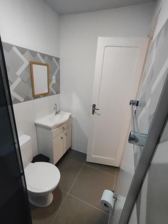 a bathroom with a white toilet and a sink at Apto studio 302 centro de Florianópolis in Florianópolis
