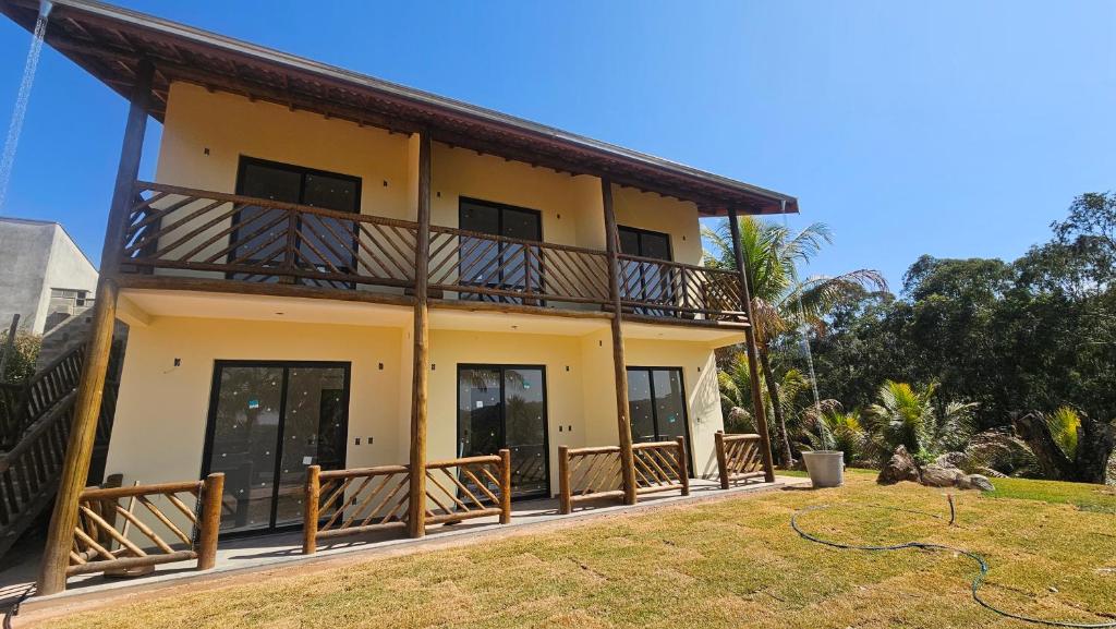 a house with a balcony and a yard at Pousada do Barão in Lindóia