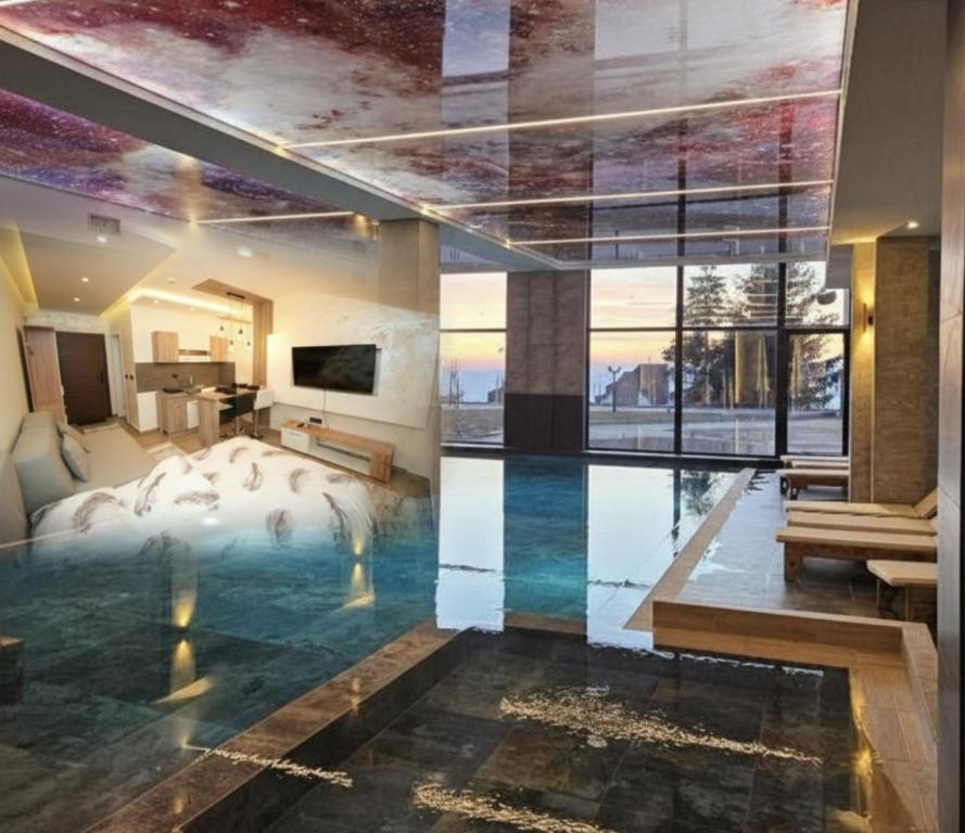 a hotel room with a pool in the middle of a bedroom at Residence Hill - Planinski Kutak in Kopaonik