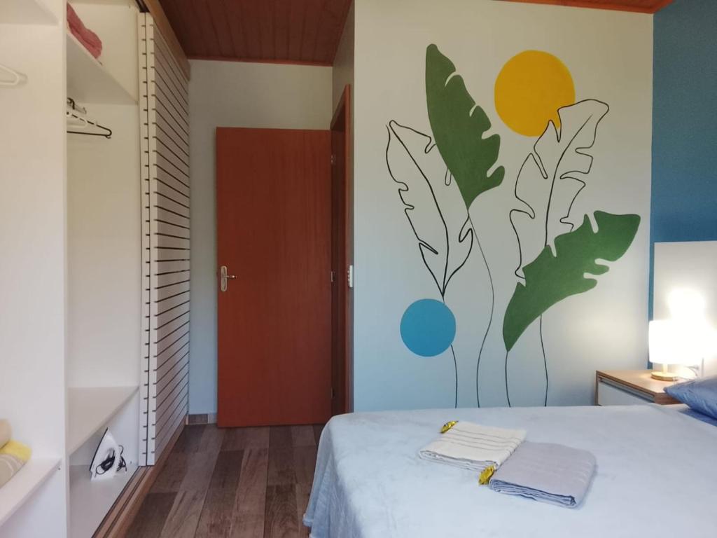 una camera da letto con un letto con due asciugamani sopra di A Casa Amarela - Morada dos Maçaricos - Tranquilidade próxima ao mar a Balneário Gaivotas