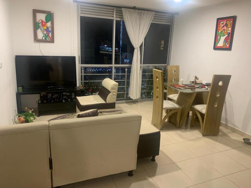 a living room with a tv and a table with chairs at Tucurumbi entrada quimbaya in Quimbaya